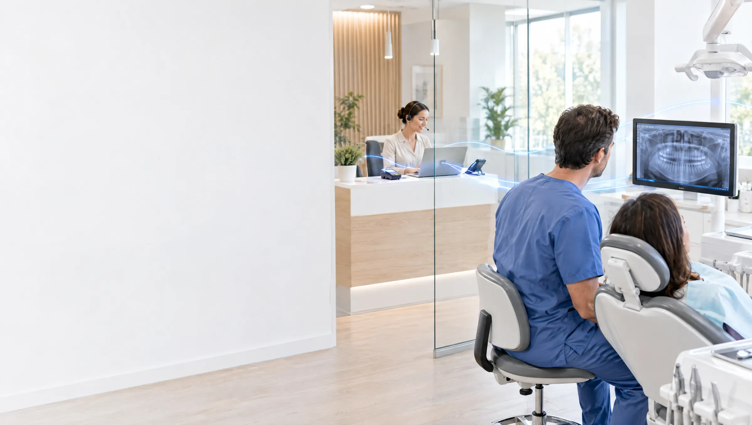 A modern dental practice: a receptionist with a headset at the front desk and a dentist reviewing an X-ray on a monitor beside a patient